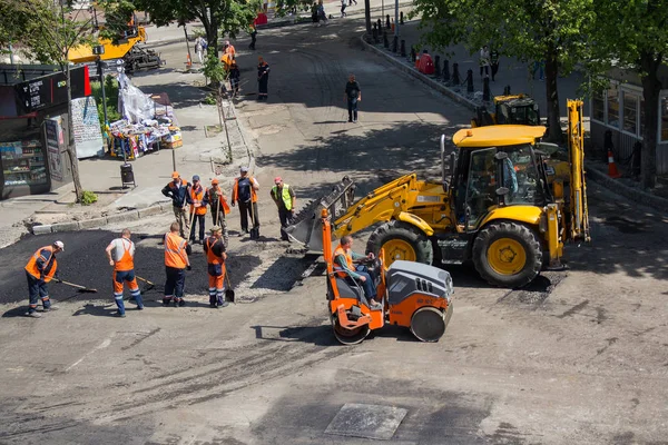 Kiev, Ucrania - 12 de mayo de 2018: Los trabajadores colocan masilla sobre asfalto durante los trabajos de reparación de calles — Foto de Stock