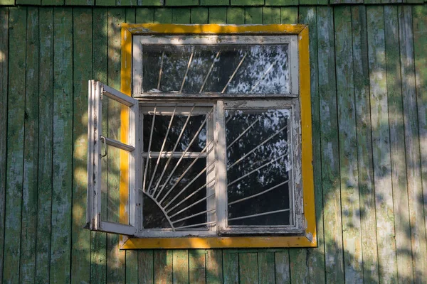 Altes Holzfenster mit von der Sonne beleuchtetem Grill — Stockfoto