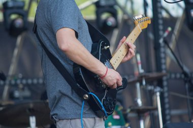 Konserde solo çalarken sahnede performans sergileyen elektro gitaristler