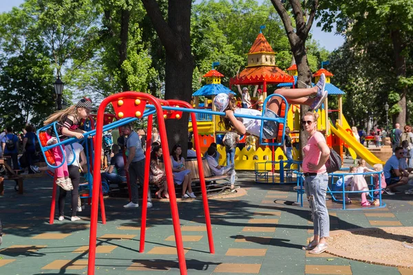 Kiev, Ucrania - 19 de mayo de 2019: Los niños en presencia de sus padres montan en un columpio en el patio de recreo el fin de semana — Foto de Stock