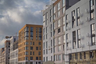 Gökyüzüne karşı yapım aşamasında olan çok katlı bir binanın cephesi. Şantiye