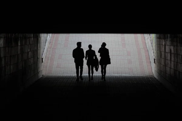 Silhouettes de trois jeunes dans le passage souterrain — Photo