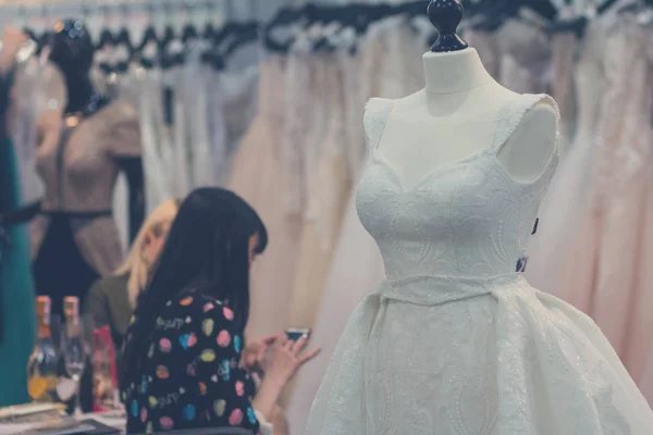 Belos vestidos de noiva e clientes no salão — Fotografia de Stock