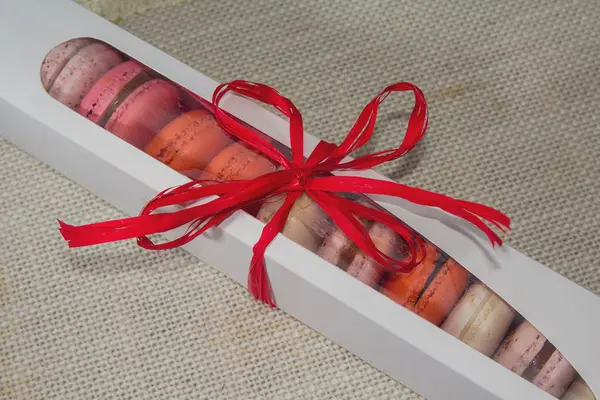 Tekstil arka planda bir hediye kutusunda renkli macaroons. Hediyeler ve romantizm — Stok fotoğraf