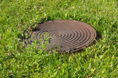 Yeşil çimenlikte kanalizasyon rögar. Doğa