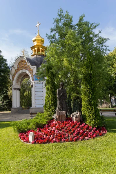 Standbeeld van Jezus omringd door bloemen op de binnenplaats van de Mahaylovsky kathedraal. Kiev, Oekraïne — Stockfoto