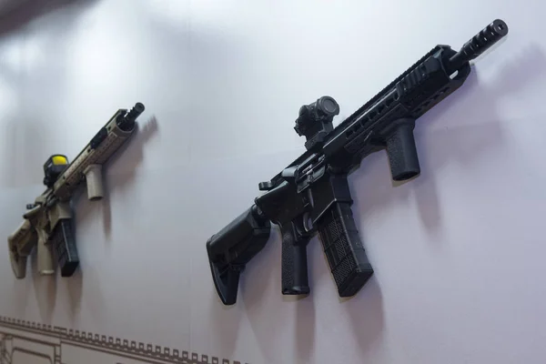 Uma espingarda de assalto pendura numa parede numa loja de armas. Armas — Fotografia de Stock