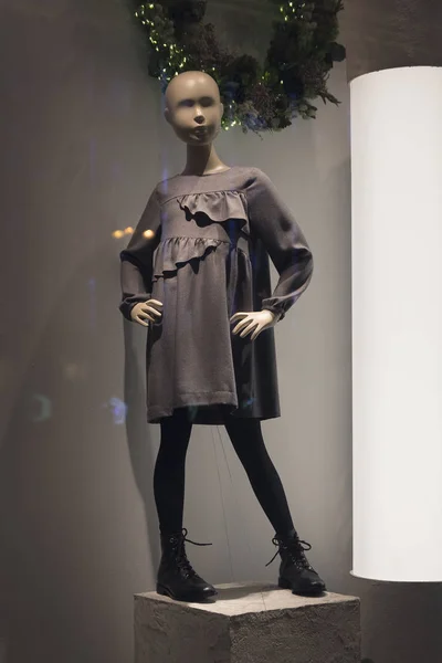 Παιδική κούκλα με ένα φόρεμα σε ένα παράθυρο καταστήματος. Μόδας — Φωτογραφία Αρχείου