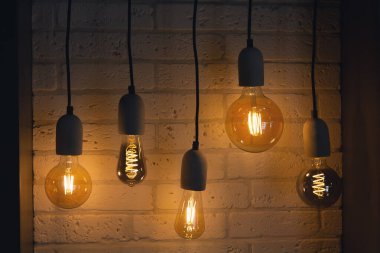 Beyaz arka planda asılı klasik tarzda ampuller. Dekor