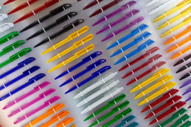 Tezgahın üzerine çok renkli plastik kalemler. Satılık.