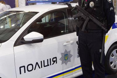 Bir servis arabasının yanında silahlı Ukraynalı polis memuru. Güvenlik.