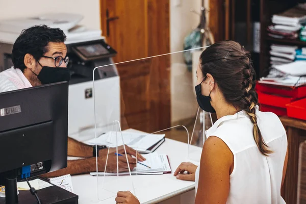 Maskeli ya da maskesiz danışman odasında çalışanlar.