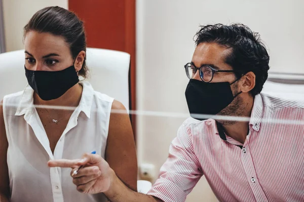 Maskeli ya da maskesiz danışman odasında çalışanlar.