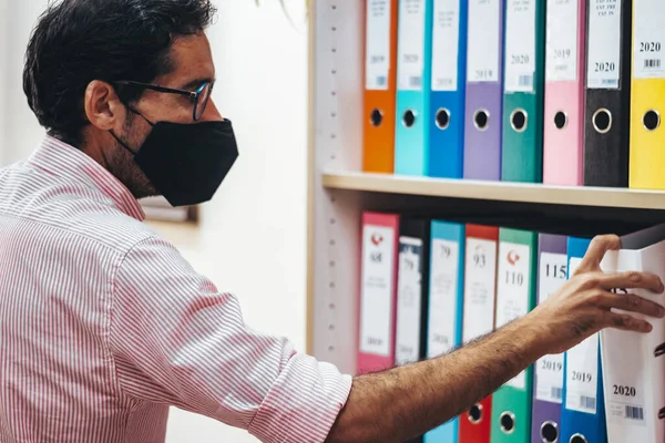 Maskeli ya da maskesiz danışman odasında çalışanlar.