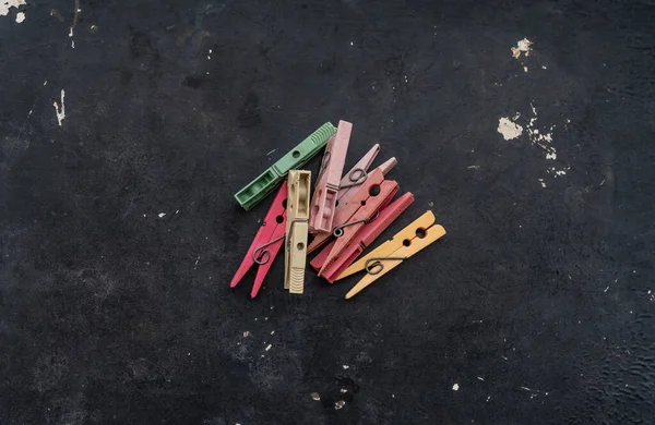 muchos broşürler para la ropa de diferentes colores en un fondo negro gastado