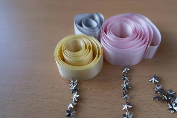 Cintas de diferentes colores y tachas para la ropa presentadas de una manera artistica.