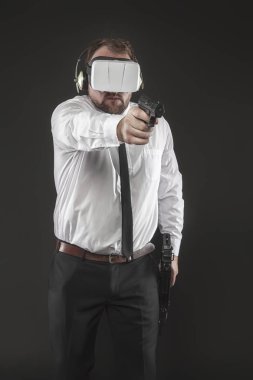 İşadamı sanal gerçeklik gözlük takan ve bir silah tutan bir oyun oynuyor