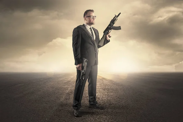 Businessman holding a machine gun — Stock Photo, Image