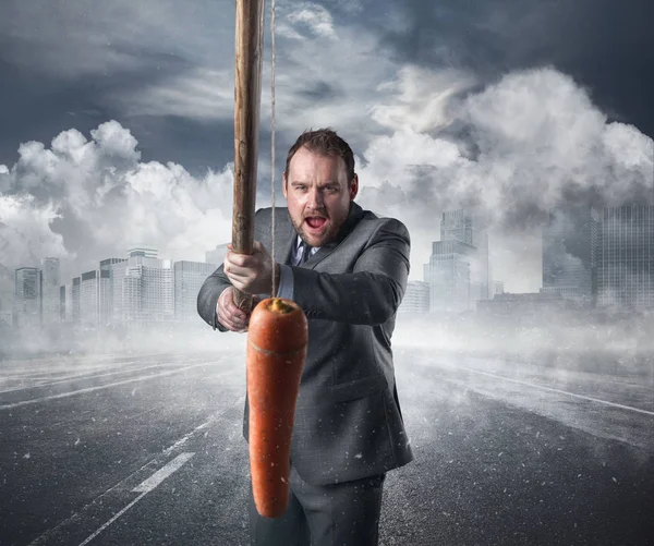 Zakenman met een wortel in een stok — Stockfoto