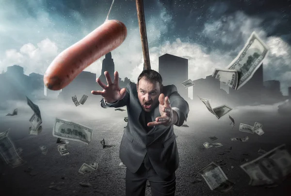 Podnikatel, drží mrkev v tyči — Stock fotografie