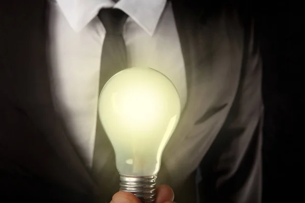 Businessman holding light bulb — Stock Photo, Image