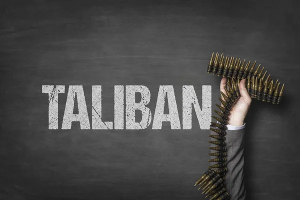 Taliban text on blackboard with businessman hand holding ammunition — Stock Photo, Image