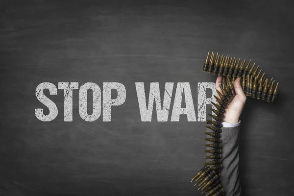 Stop war text on blackboard with businessman hand holding ammunition — Stock Photo, Image