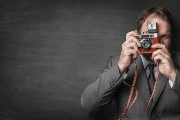 Businessman taking a photo with old vintage camera — Stock Photo, Image