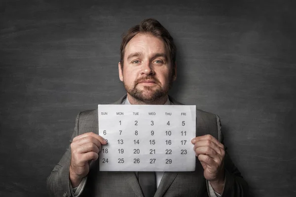 Businessman showing paper calendard in front of him — Stock Photo, Image