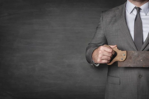 Businessman holding vintage saw — Stock Photo, Image