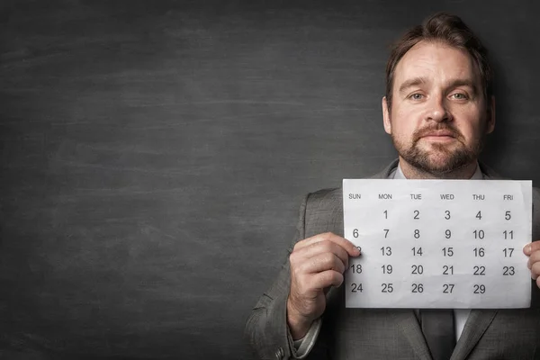 Businessman showing paper calendard in front of him — Stock Photo, Image