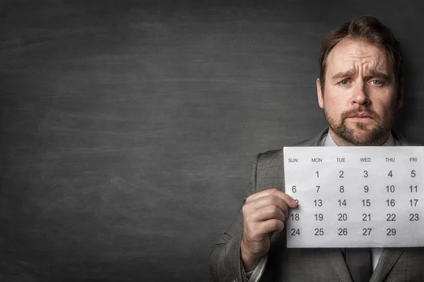 Businessman showing paper calendard in front of him — Stock Photo, Image