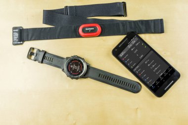 Niedomice, Polonya - 08 Haziran 2018: Sporcu seyretmek (smartwatch), kalp atış hızı monitörünü (karınca +) ve sonuçları ile akıllı telefon çalışır durumda ve günlük aktivite.