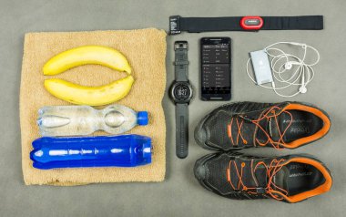 Niedomice, Polonya - 08 Haziran 2018: Ekipman eğitim bir atlet için. Nabız ölçüm seti - kalp oran sınıf başkanı (giyim eşyası), izotonik bir içki, muz, bir havlu, bir ipod kuru ceket (elma) ve koşu ayakkabıları (Dynafit ile).