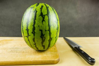 Karpuz kesme için hazır bir ahşap tahta üzerinde.