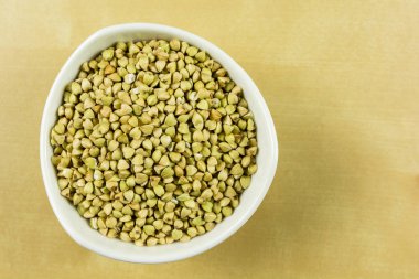 Beyaz bir kase içinde bir kapta buğday. Yukarıdan görüntülemek.