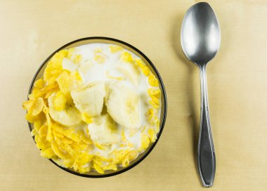 Mısır gevreği genellikle soğuk süt ve meyve, örneğin, bir muz sunulmaktadır. Yukarıdan görüntülemek.