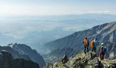 Tatranska Lomnica, Slovakya - 04 Ağustos 2018: Bir rehber istemcileri bir çift ile bir dağ tepe üzerinde.