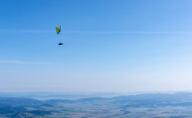Tatranska Lomnica, Slovakya - 15 Eylül 2020: Güneşli bir günde vadinin üzerinde uçan bir paraglider.