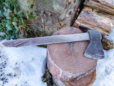 Donmuş odunların üzerinde duran küçük bir balta.