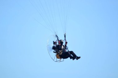 Paramotor sporcuları açık mavi renkte uçuyor