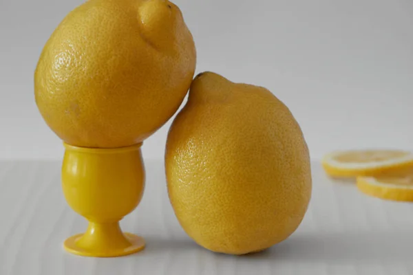 Birkaç sarı dilimlenmiş ve tüm limonlar arka planda hafif bir tahtaya yerleştirilmiş.