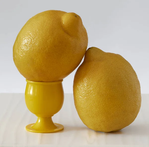 Birkaç sarı dilimlenmiş ve tüm limonlar arka planda hafif bir tahtaya yerleştirilmiş.