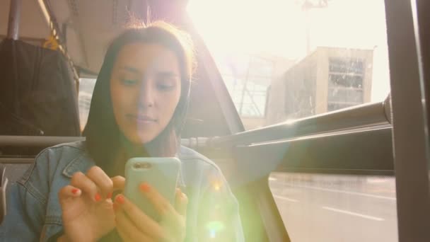 Jong gemengd ras toeristische vrouw in de Bus met behulp van mobiele slimme telefoon op luchthaven. 4k. — Stockvideo