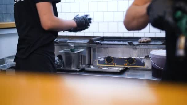 Szakácsok sütés hamburgert egy Grill étterem konyha tűzhely. 4k. — Stock videók
