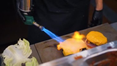 Yangın soba yanan kullanarak ve Burger Restoran mutfağında yapma Vegan peynir erime Şef. 4k Slowmotion.