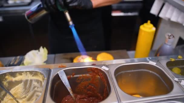 Tání Vegan sýr pomocí kamna Fire a hamburger v restauraci kuchyni šéfkuchaře. 4k Slowmotion. — Stock video