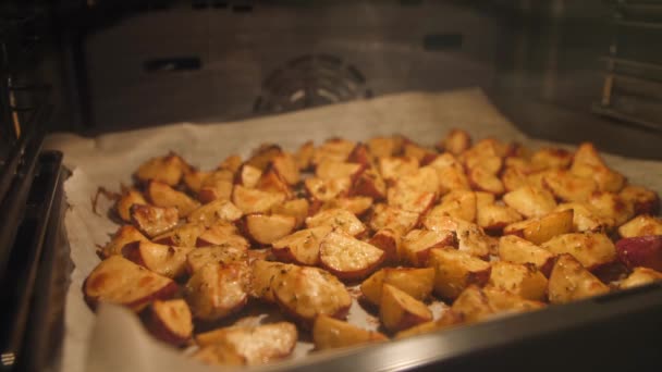 烤土豆与迷迭香, 大蒜, 胡椒和百里香在烤箱。健康素食饮食或烹饪食谱概念4k 素材. — 图库视频影像