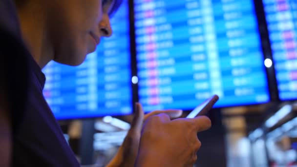 Junges Gemischtes Touristenmädchen Mit Mobiltelefon Der Nähe Der Abflugtafel Flughafen — Stockvideo