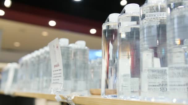 Botella de agua tónica de mano femenina de la estantería en la tienda de cuidado corporal. Mujer Compradora Comprando Cosméticos en la Tienda. 4K cámara lenta . — Vídeos de Stock